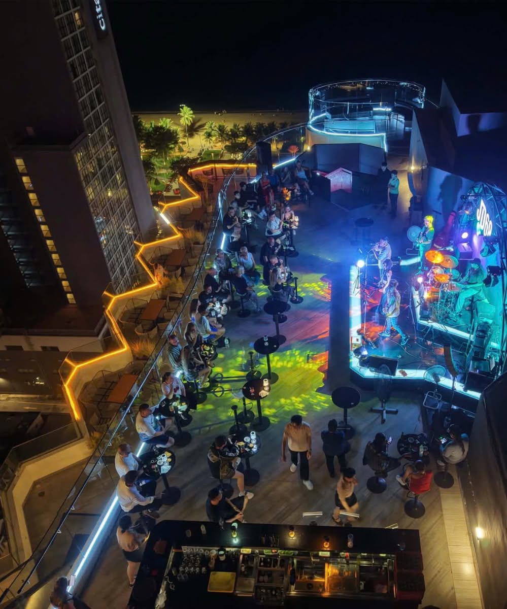 Elevated view across the JD68 rooftop and live stage at night